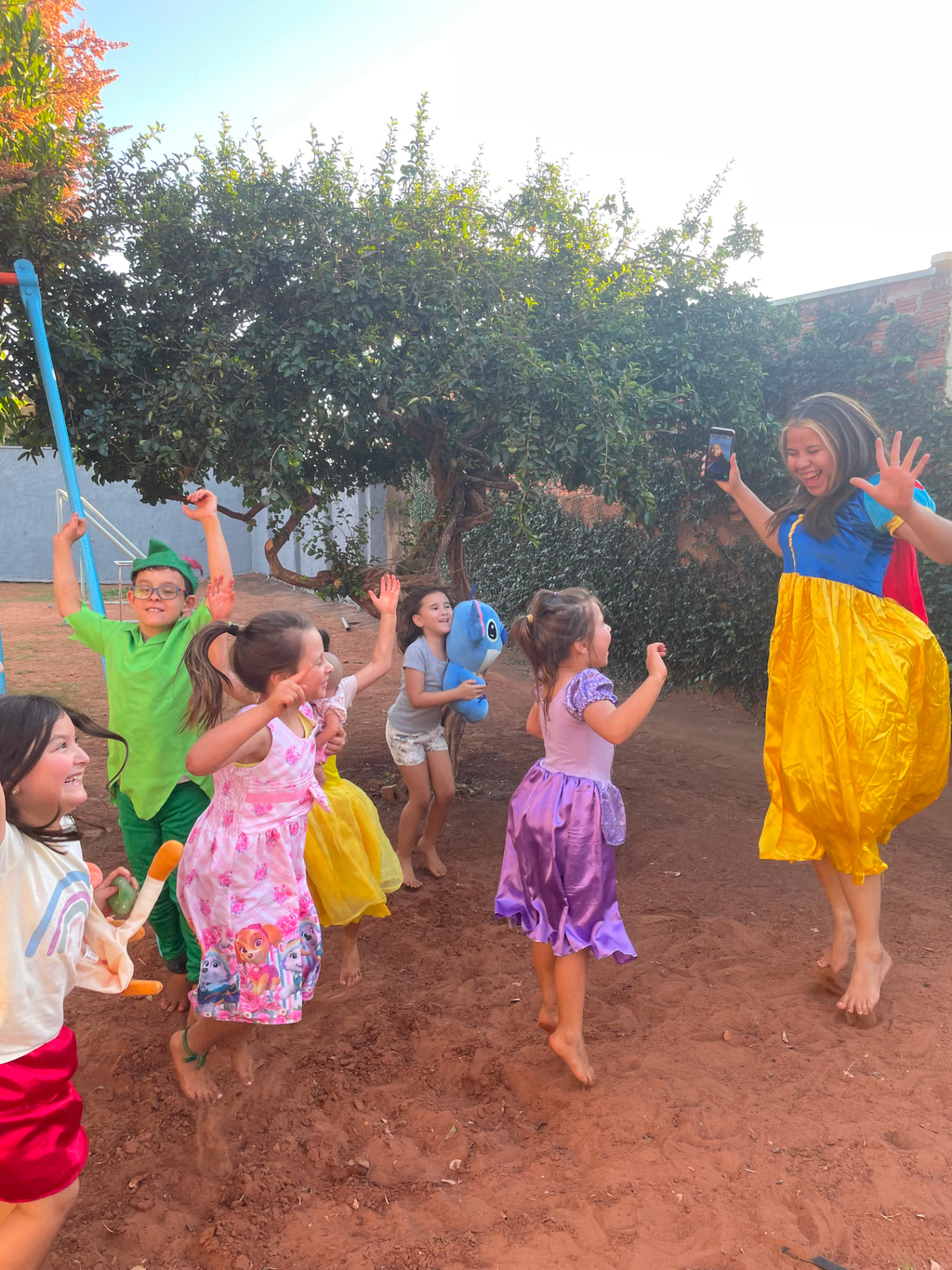 Crianças fantasiadas dançando e brincando na área externa da Talsce.