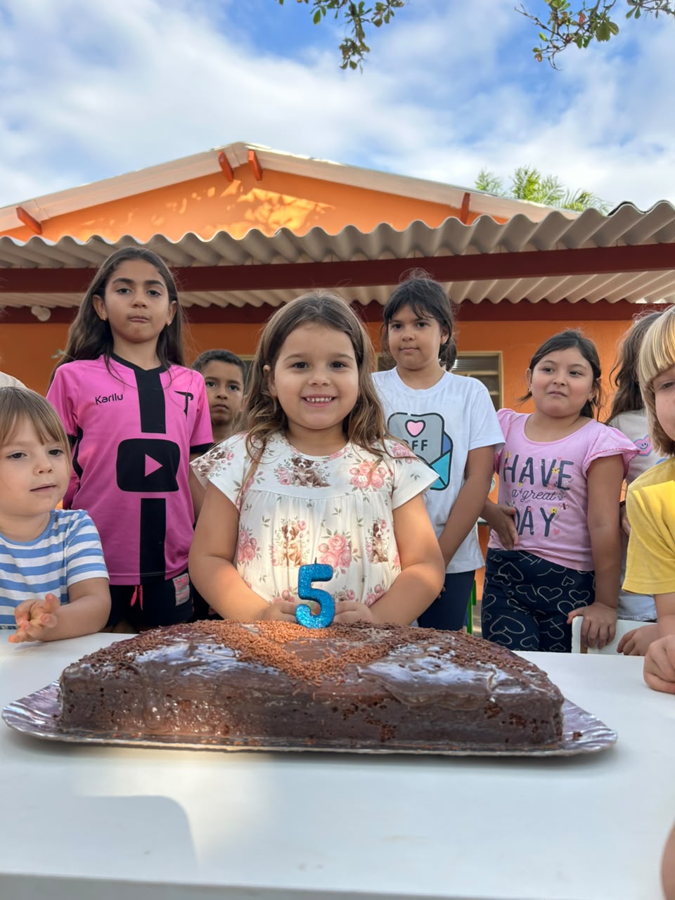 Crianças reunidas em volta do bolo em uma festa de aniversário na Talsce.